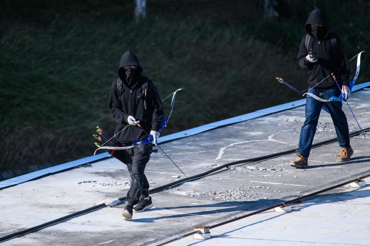 Protesters walk with bows and arrows near the Hong Kong Polytechnic University on November 16, 2019.