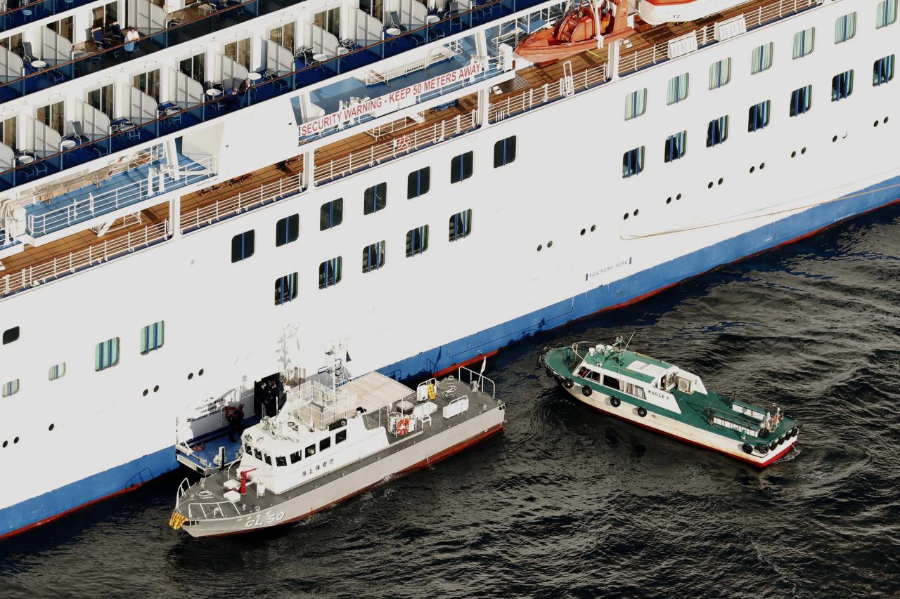 A Japanese Coast Guard patrol boat is brought alongside the Diamond Princess cruise ship to transport passengers who have tested positive for coronavirus to hospitals in Yokohama, Japan on Wednesday.