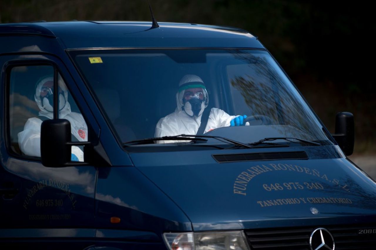 Mortuary workers in full protective gear ride in a hearse in Ronda on April 3, amid a national lockdown to prevent the spread of the coronavirus. 