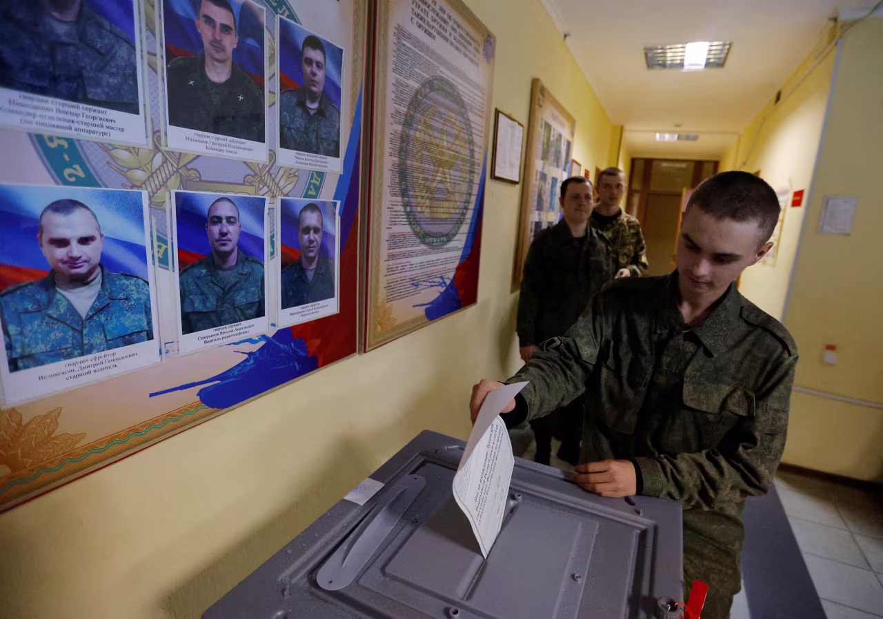 A service member of the self-proclaimed Luhansk People's Republic (LPR) casts his vote during a referendum on joining LPR to Russia, at a military unit in Luhansk, on Friday.