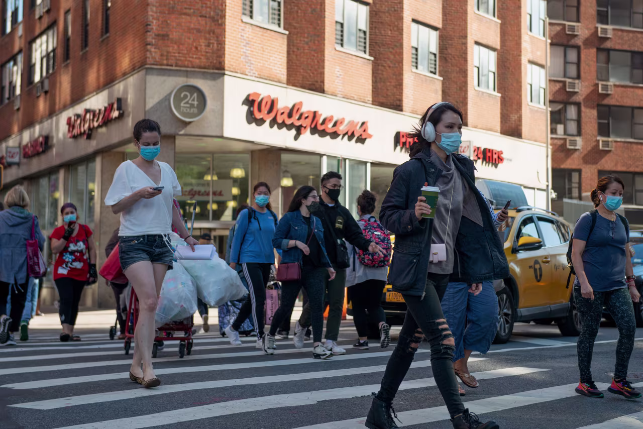 People cross the street near a Walgreens store on September 30 in New York City. 
