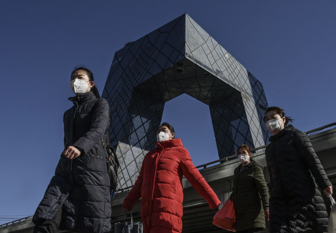 Chinese women wear protective masks on their way to work in Beijing.