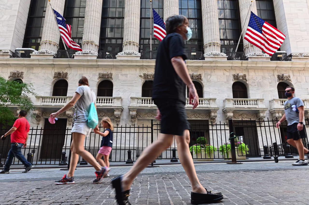 People walk past the New York Stock Exchange on August 3 in New York.