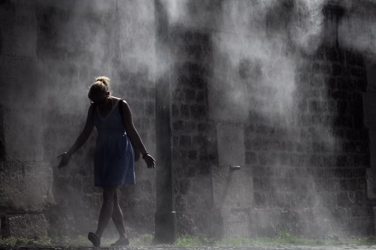 A woman cools off under a public water spray on the bank of the River Seine in Paris on Thursday as Europe's second heat wave of the year peaks. 