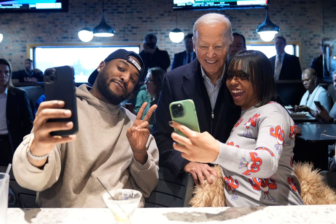 President Joe Biden, center, takes photos with patrons at They Say restaurant during a campaign stop Feb. 1, 2024, in Harper Woods, Michigan.