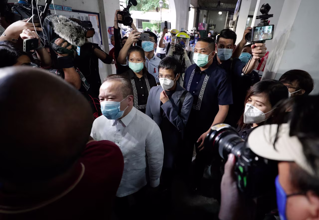 Rappler CEO and Executive Editor Maria Ressa, center, is escorted as she arrives to attend a court hearing at the Manila Regional Trial Court on June 15, 2020.