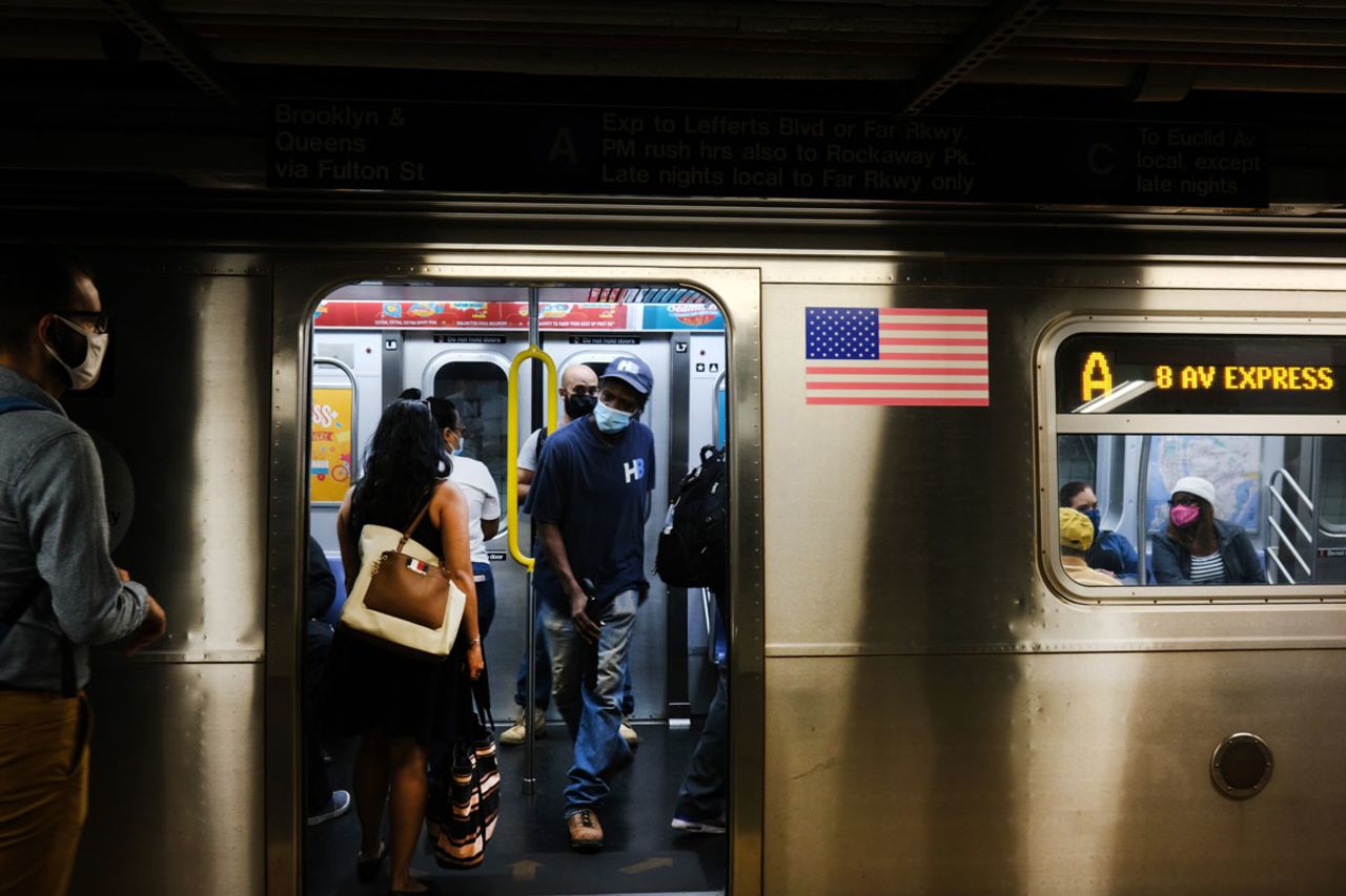 People wearing face masks take the subway on September 10 in New York City.