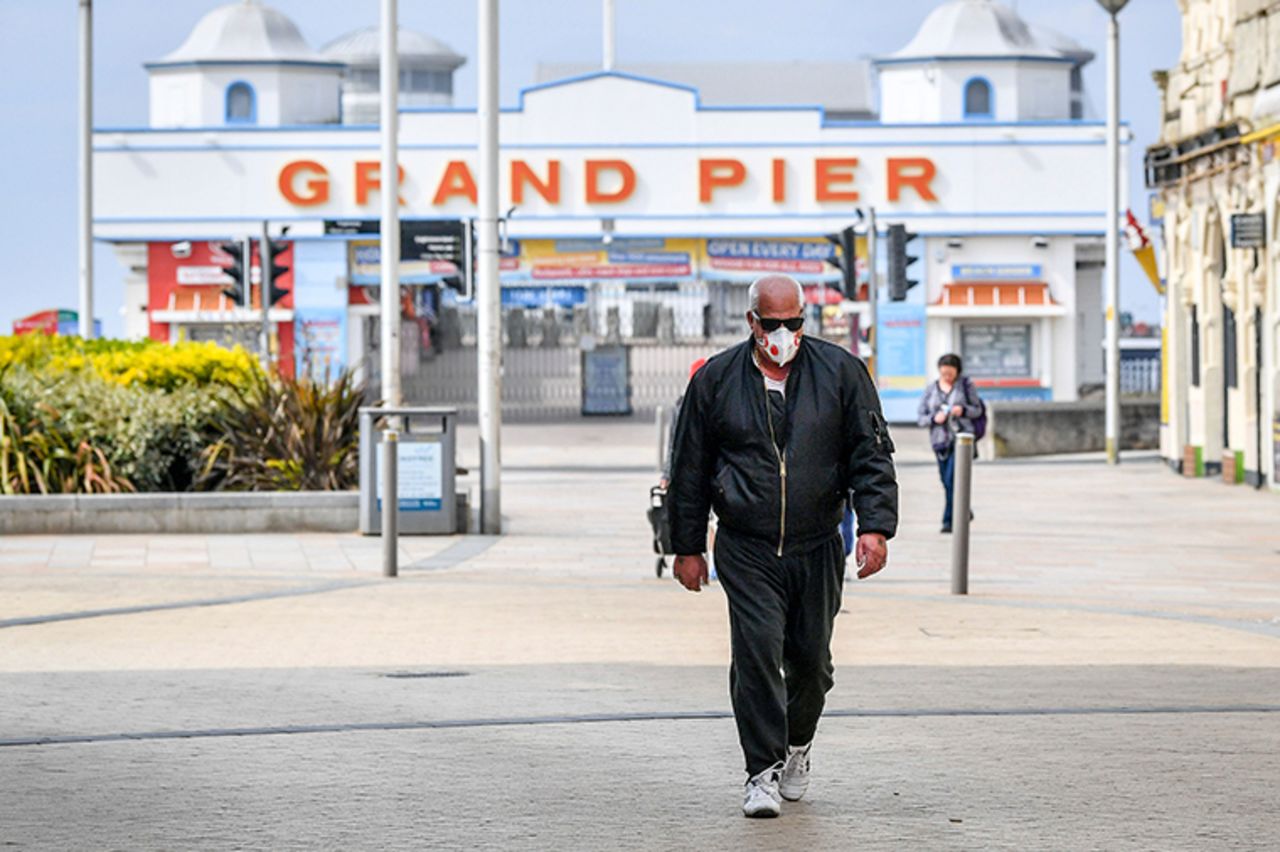 A man wearing a mask walks in front of the closed Grand Pier around midday on Easter Sunday at Weston-super-Mare, on Sunday April 12.