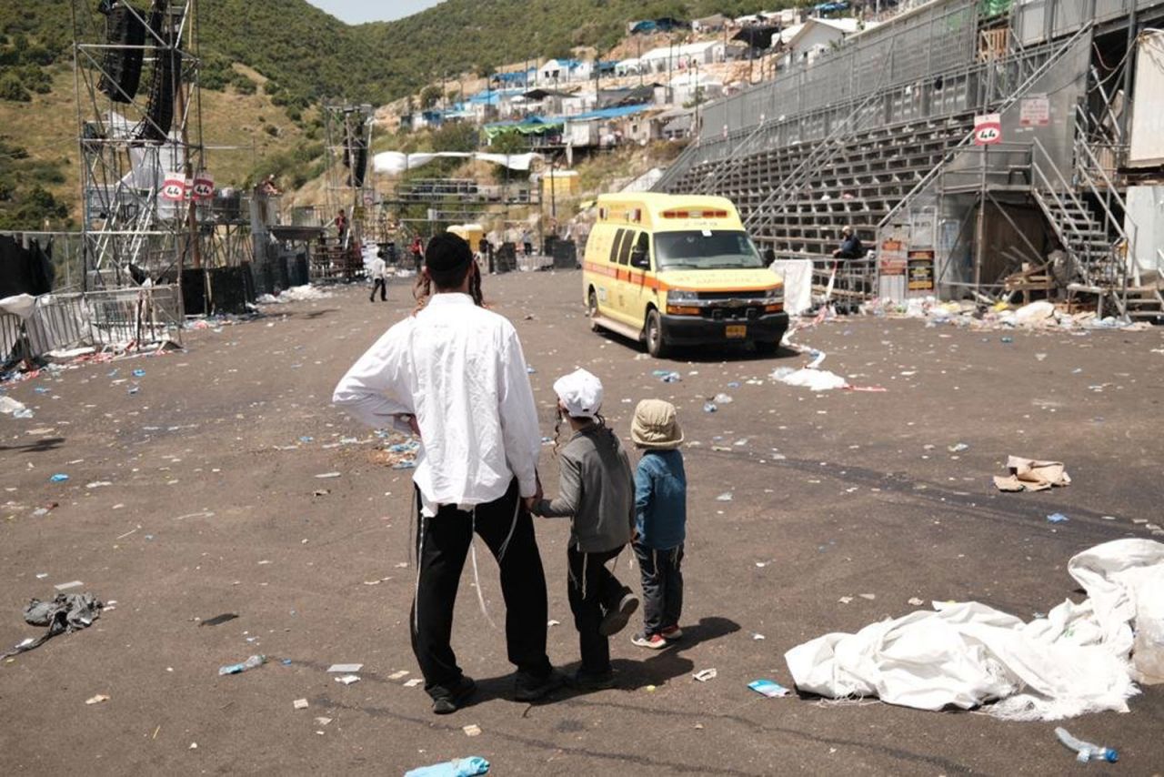 A family surveys the scene of the tragedy at Mount Meron on Friday.