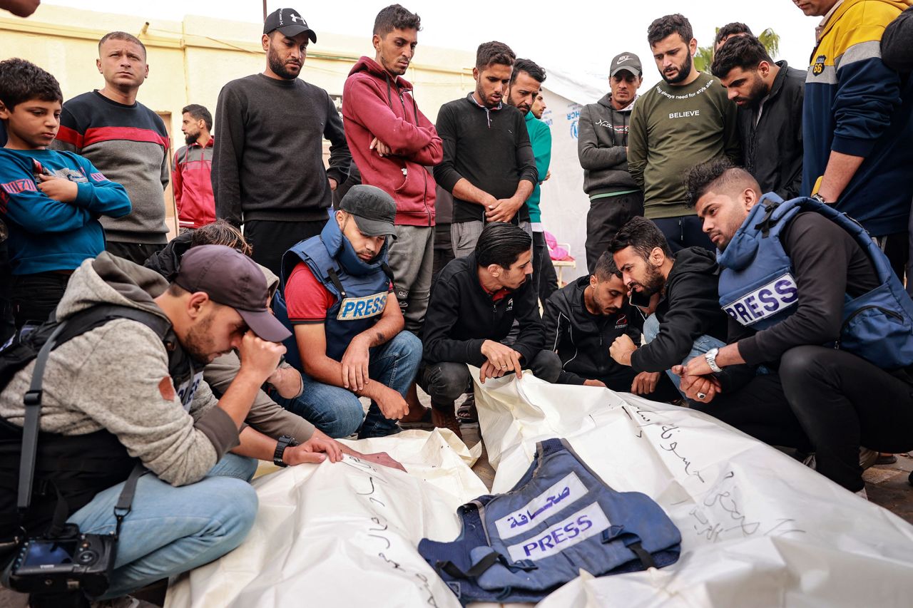 Friends and colleagues of two Palestinian journalists Hasouna Slim and Sari Mansoor, killed in an Israeli strike, mourn over their bodies during their funeral in Deir al-Balah, southern Gaza , on November 19.