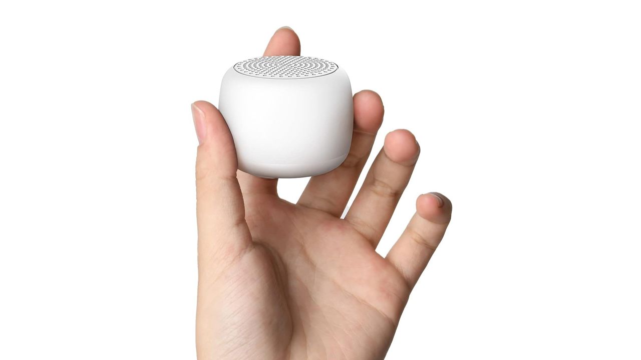 A photo of a hand holding a white Babelio Mini Sound Machine