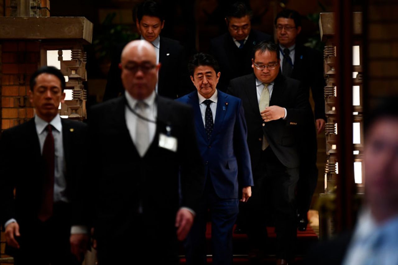 Japan's Prime Minister Shinzo Abe, center, arrives to speak to journalists in front of the prime minister's residence in Tokyo, Tuesday, March 24. 