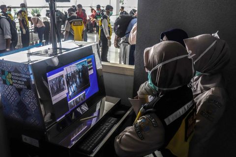 Health officers monitor a thermal scanner as passengers from Singapore, China and Hong Kong arrive at Juanda International Airport in Surabaya, East Java, Indonesia, on January 30.