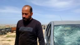 Hamdan Ballal está de pie frente a su coche, que fue vandalizado por colonos israelíes en su aldea en la Ribera Occidental ocupada el lunes.