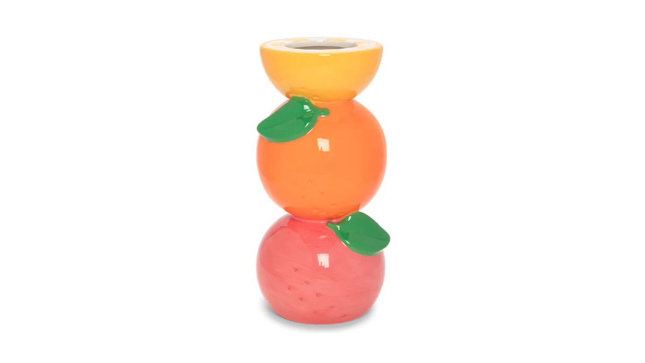 A vase of stacked citrus fruits.