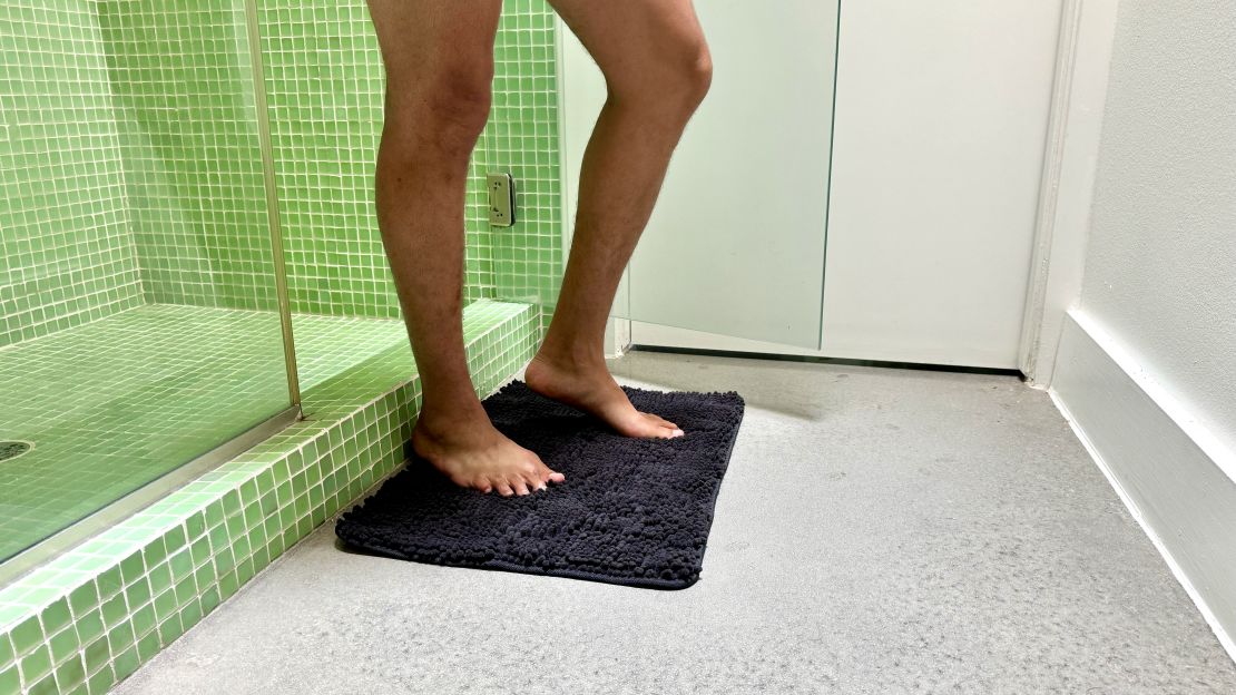 Feet stepping out of the shower onto Gorilla Grip bath rug.