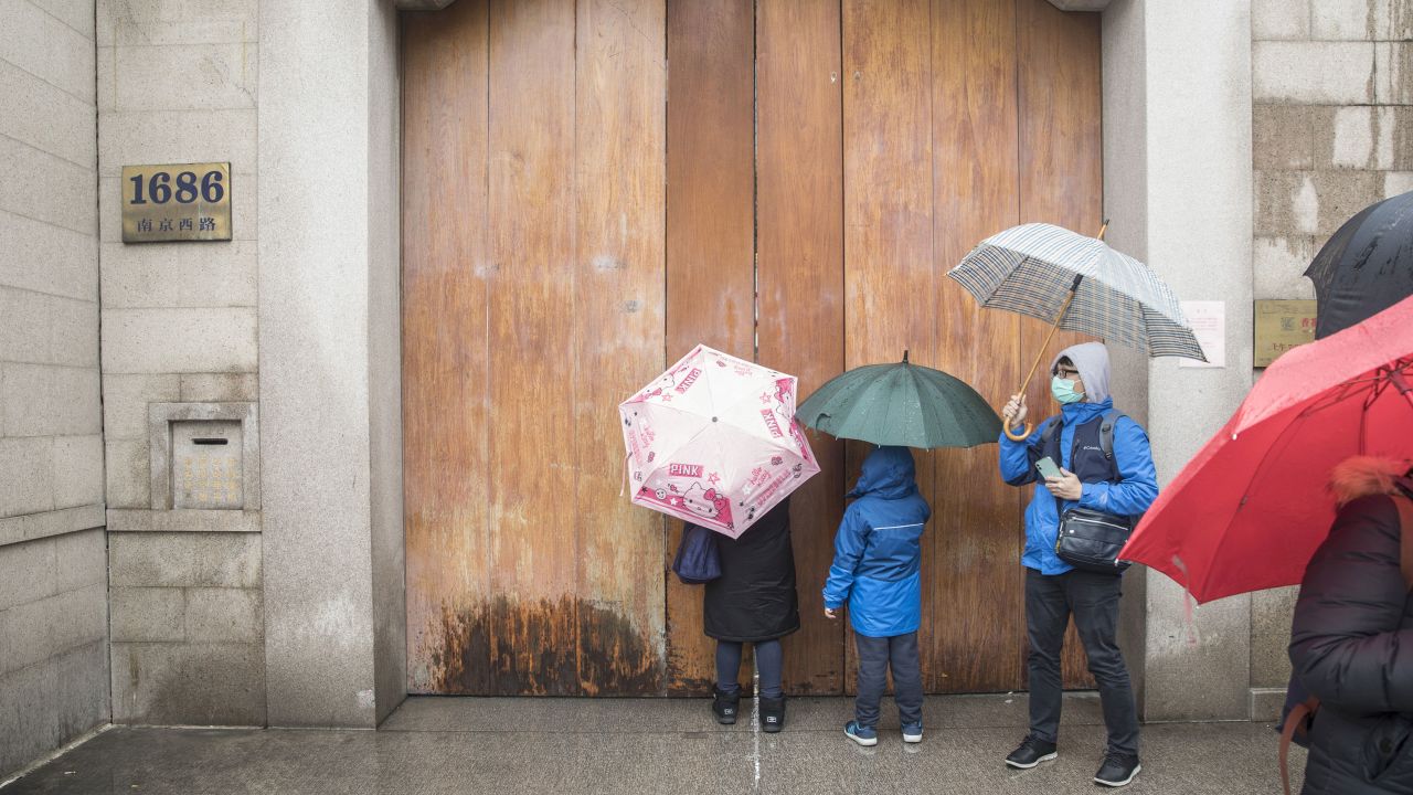 Visitors stand outside a closed temple in Shanghai, China, on Saturday, January 25.