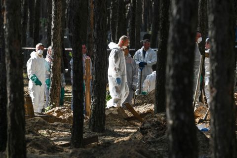 Forensic technicians at the site of a mass grave on the outskirts of Izium on Sunday.