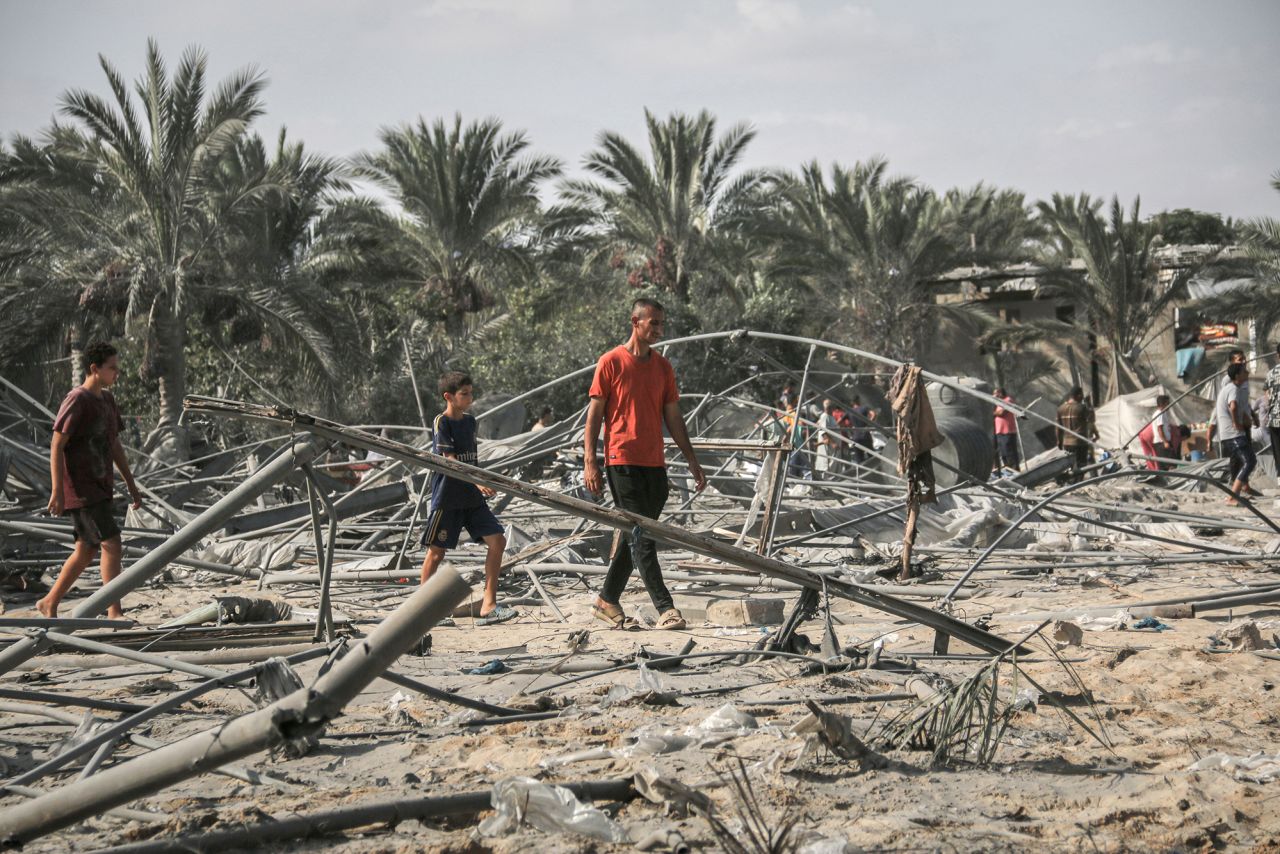 Palestinians walk through the remains of a tented area following Israeli airstrikes in the humanitarian zone, known as Al-Mawasi, in Khan Younis, Gaza, on September 10.