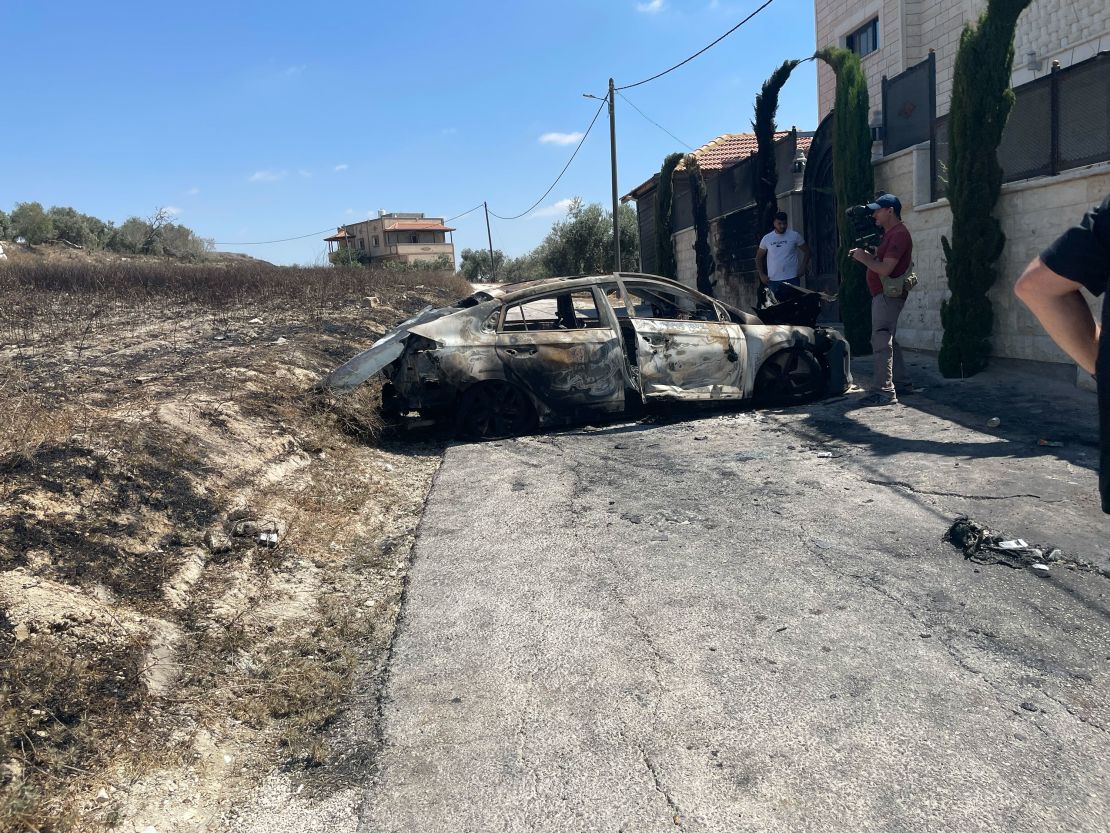 A car of a resident is damaged after being torched during a deadly settler attack on Thursday, in the West Bank town of Jit on Friday.