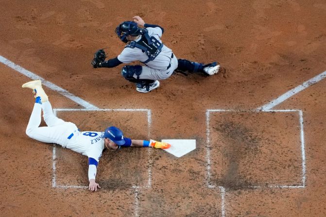 Dodgers outfielder Enrique Hernández scores past New York Yankees catcher Austin Wells on a sacrifice fly ball by Will Smith in the fifth inning of Game 1. It was the first run of the game.