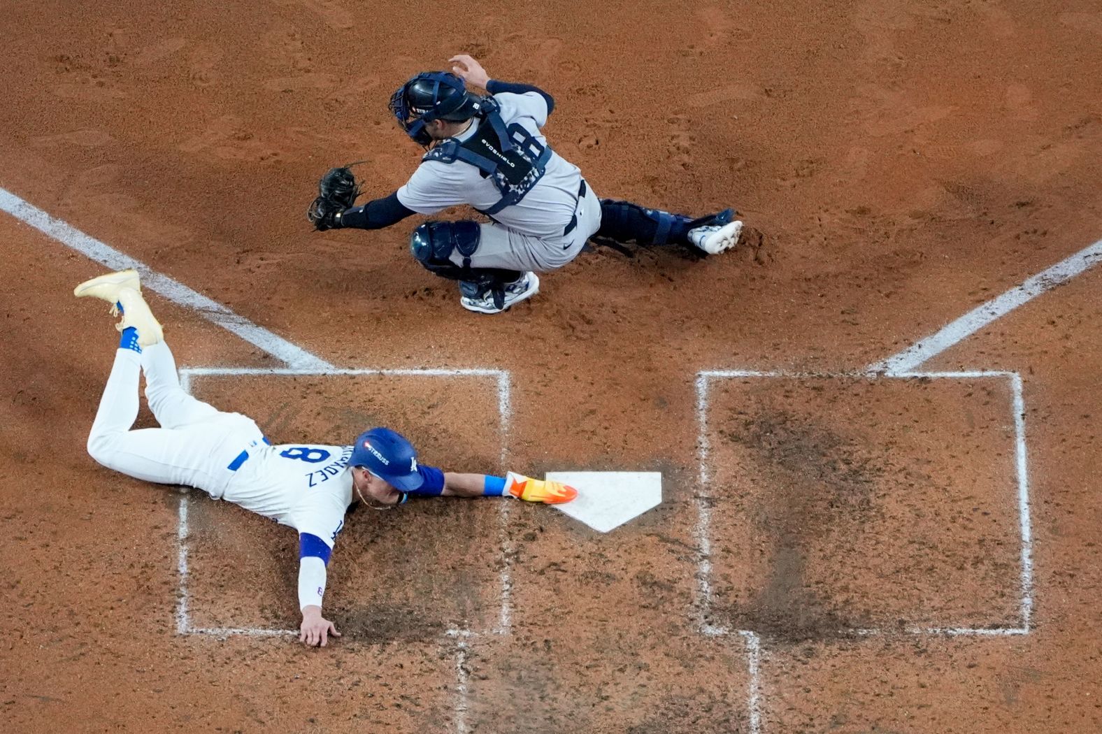 Enrique Hernández slides safely into home to score the series' first run in the fifth inning of Game 1. He scored on a sacrifice fly by Smith.