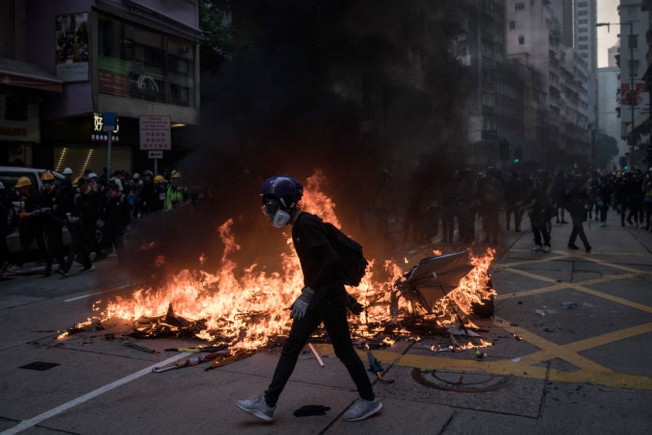 A pro-democracy protester walks in front of a burning barricade during clashes with police in Wan Chai on October 1, 2019 in Hong Kong