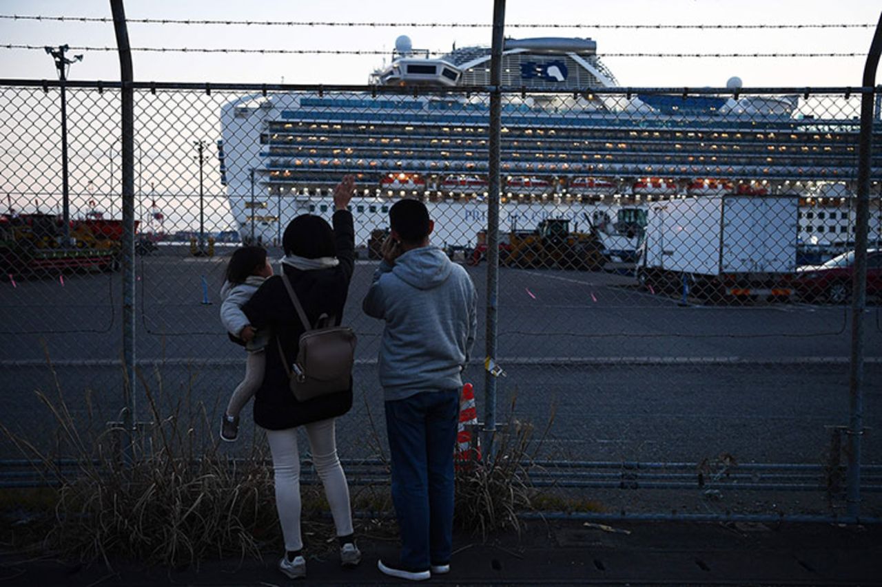 Relatives of passengers wave towards the Diamond Princess cruise ship in Yokohama on February 11, 2020.