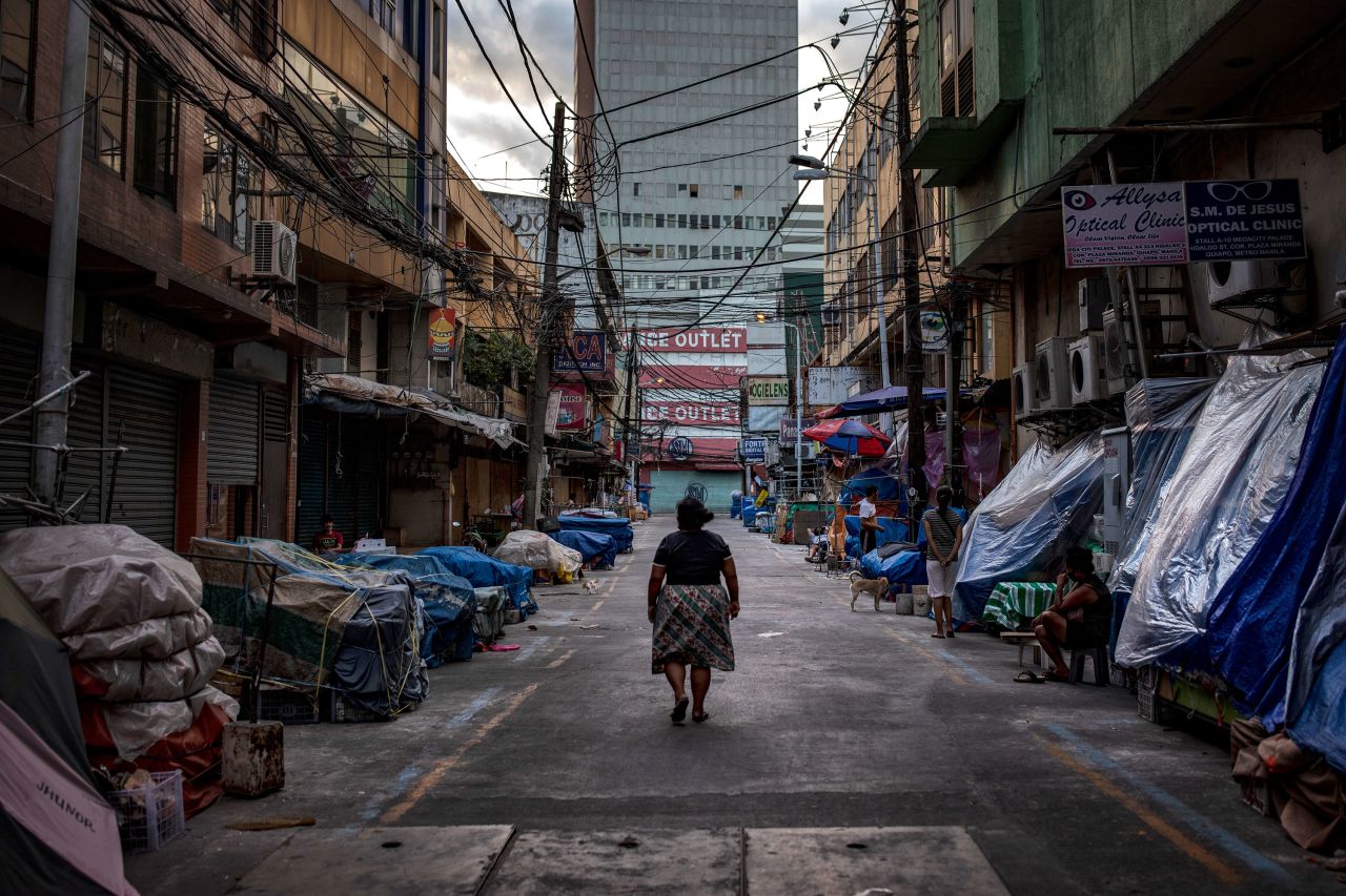 A woman walks past closed stalls at the Quiapo shopping district on March 30 in Manila, Philippines. 