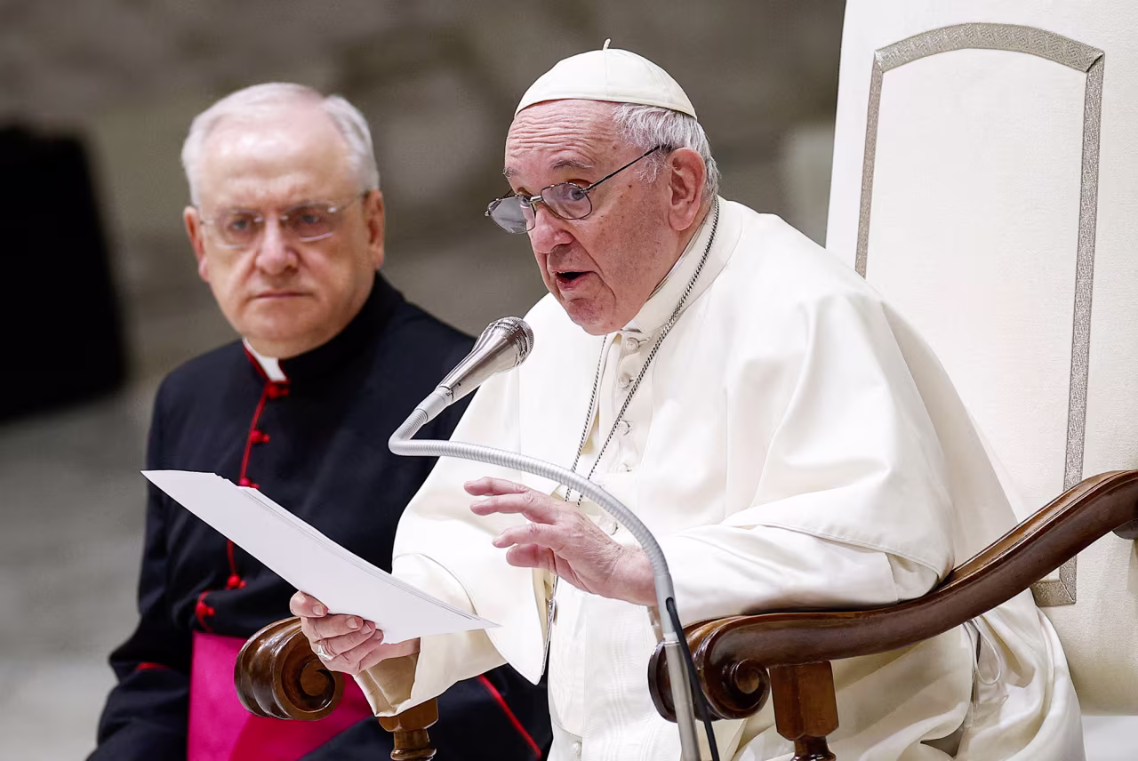 Pope Francis speaks as Prefect of the Pontifical House, Monsignor Leonardo Sapienza, left, looks on during the weekly general audience on December 14, at Paul-VI hall in The Vatican. 
