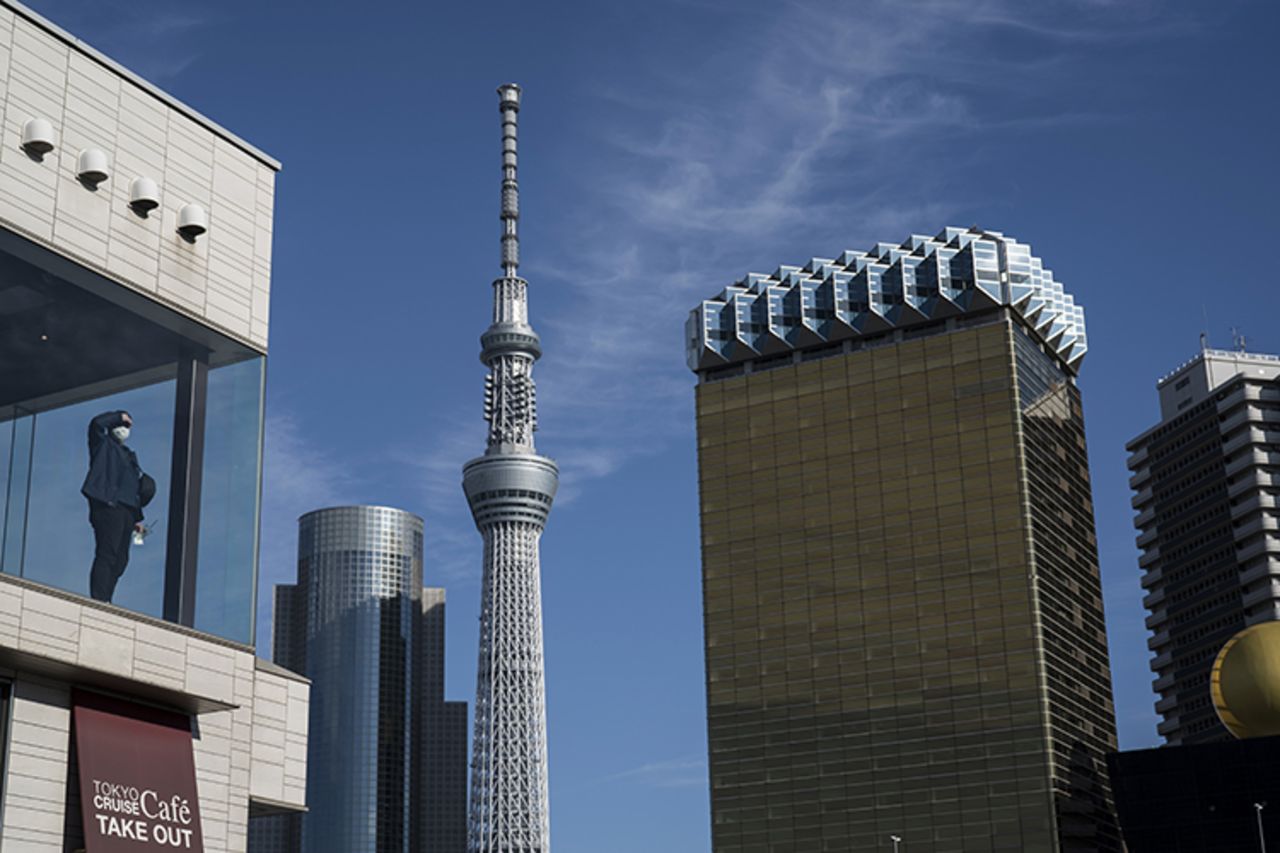 A man wearing a mask looks out of a window at a building in the Asakusa district on Sunday, February 2, in Tokyo, Japan. 