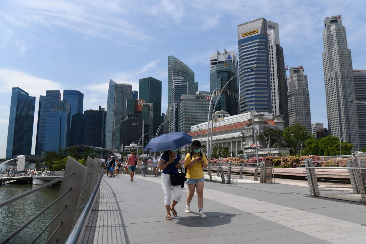 People wearing protective face masks walk along Singapore's Jubilee Bridge on Monday.