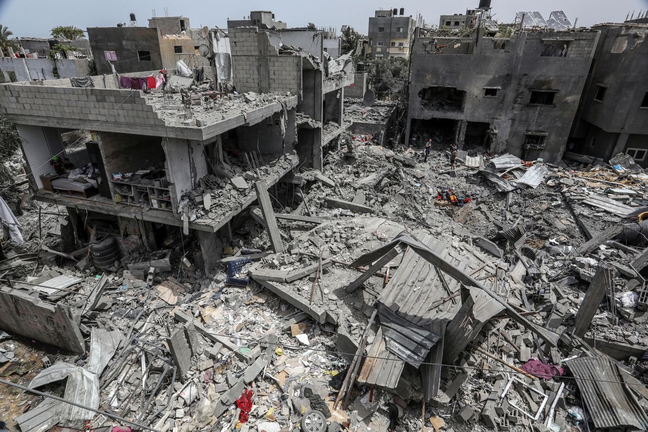 Palestinians inspect their destroyed homes after an Israeli air strike on the Nuseirat camp, Gaza, on May 19.