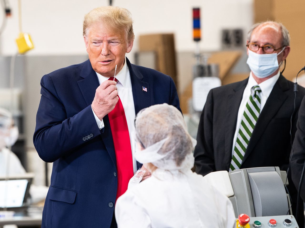 President Donald Trump pretends to take a Covid-19 test while holding a swab during his visit of the Puritan Medical Products facility in Guilford, Maine on June 5.