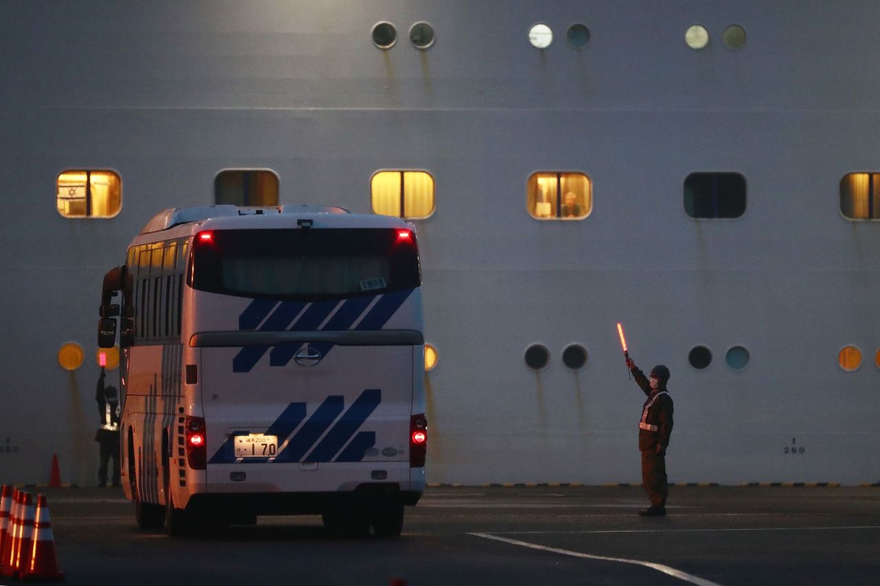 A bus arrives next to the Diamond Princess cruise ship in Yokohama port on Sunday.