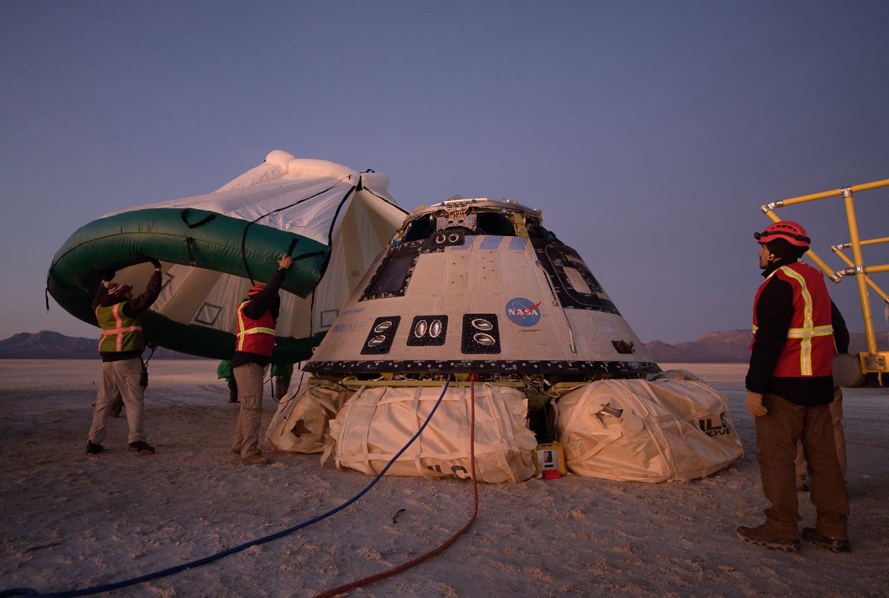 Boeing, NASA, and U.S. Army personnel in White Sands, New Mexico, work around the Boeing Starliner spacecraft in December 2019 shortly after it returned from a test flight.