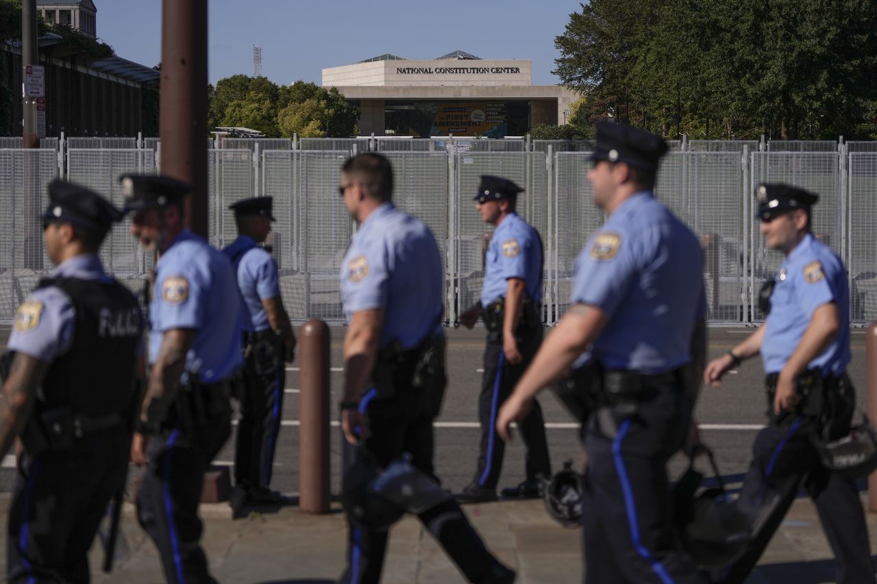 Law enforcement officers gather across the street from the National Constitution Center on Tuesday.