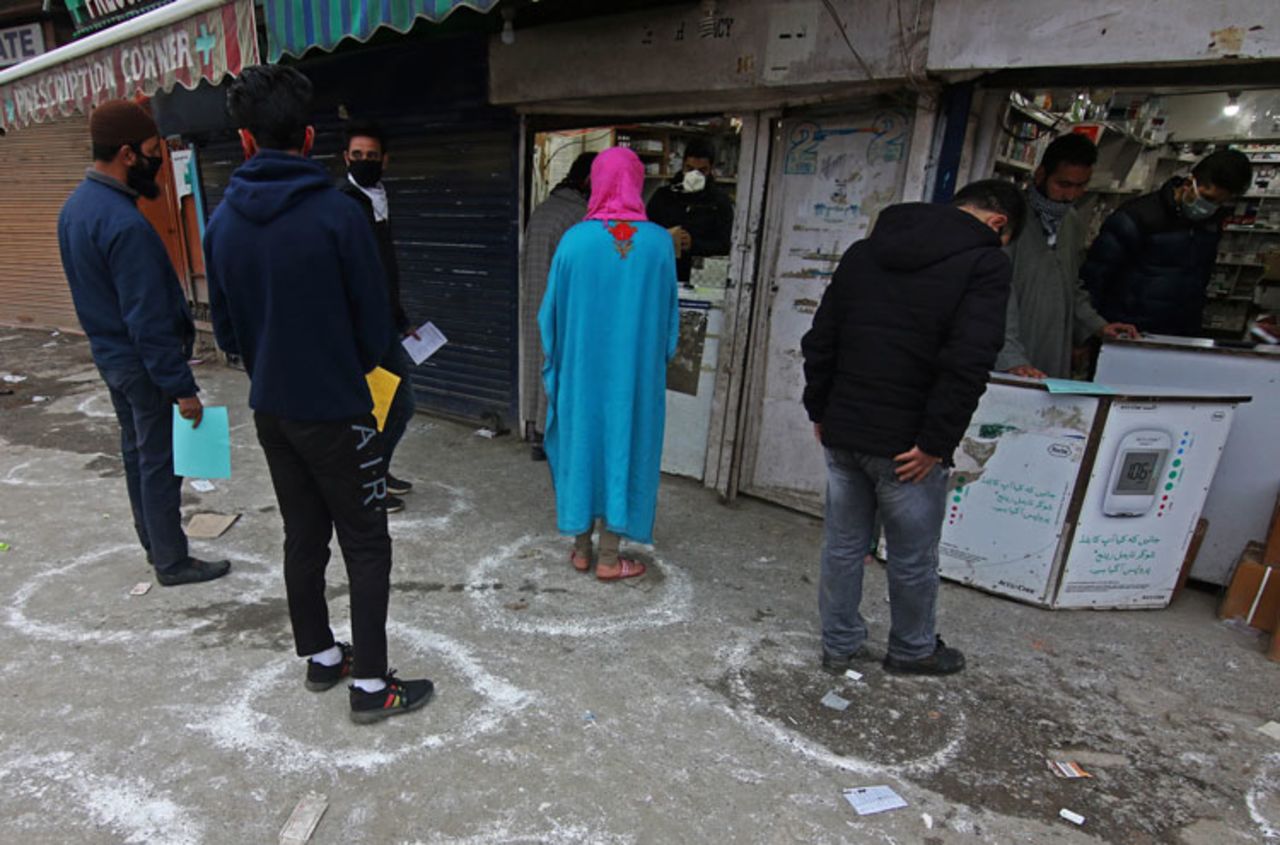 People maintain social distancing, due to the coronavirus pandemic as they wait for their turn to collect medicines from a pharmacy in Srinagar, Kashmir, India on March 26. 