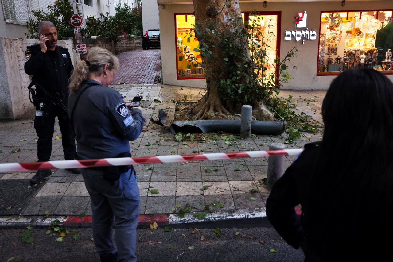 Israeli police stand next to part of a rocket fired from Gaza in Tel Aviv, Israel, on December 5.