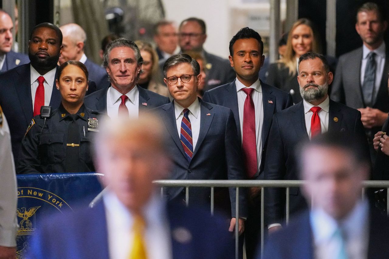 Several allies of former US President Donald Trump — including House Speaker Mike Johnson, center — watch Trump speak to reporters outside his hush money trial in New York on May 14. With Johnson, from left, are US Rep. Byron Donalds, North Dakota Gov. Doug Burgum, former presidential candidate Vivek Ramaswamy and US Rep. Cory Mills. 