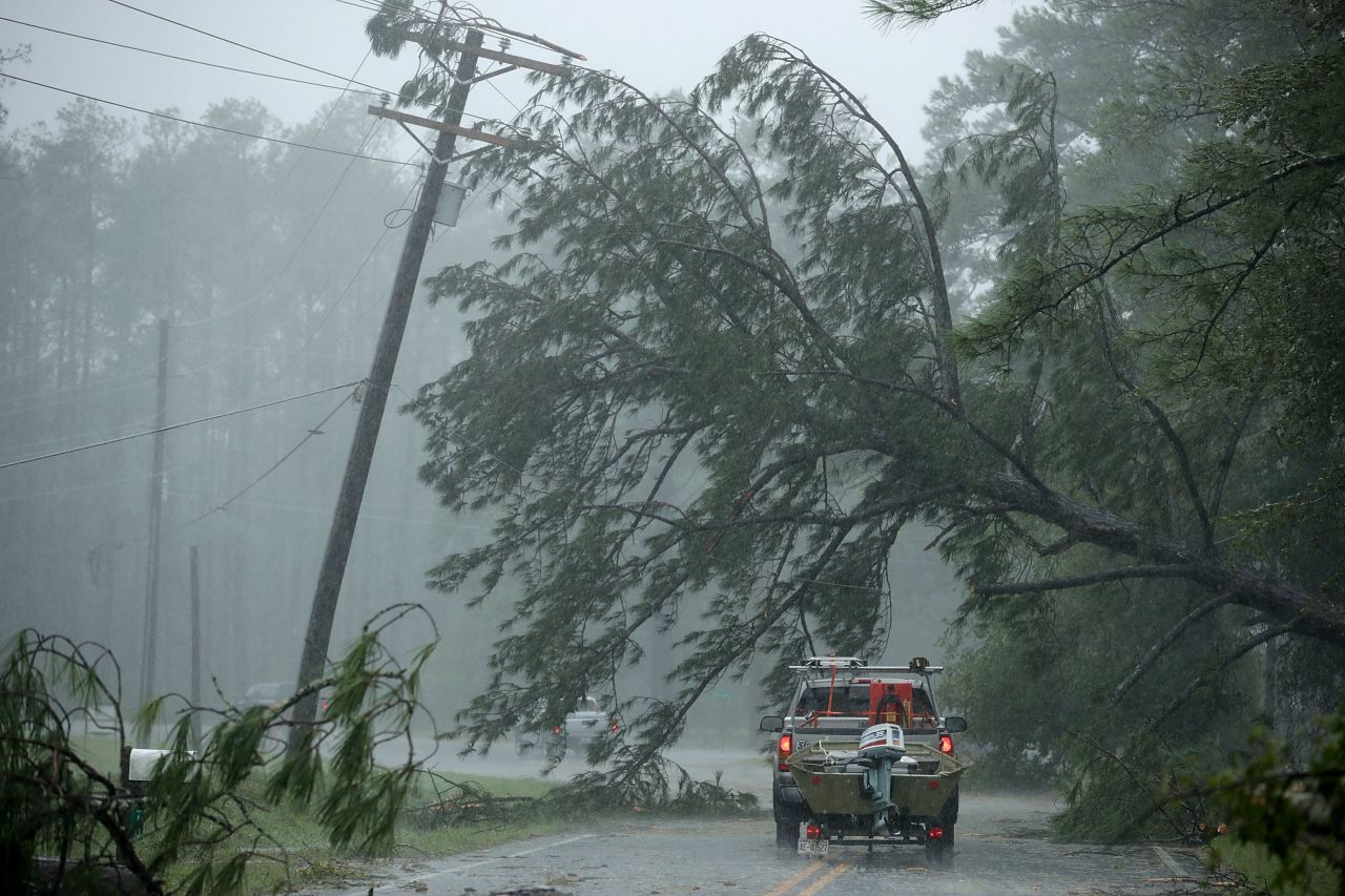 A volunteer rescue truck drives underneath a fallen tree in New Bern, North Carolina.