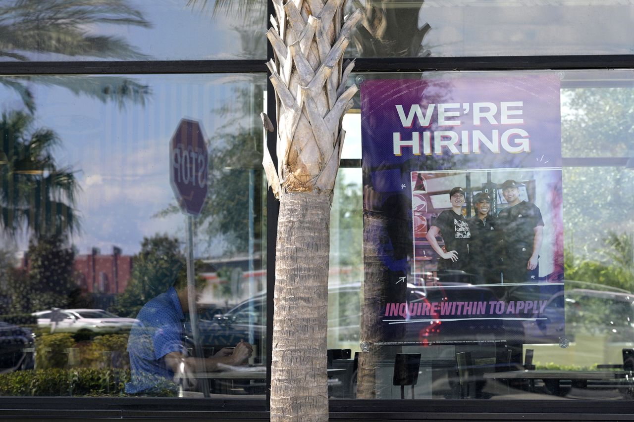 A "We're Hiring" sign advertising job openings is viewed in the window of a Taco Bell restaurant on October 20 in Orlando, Fla. 