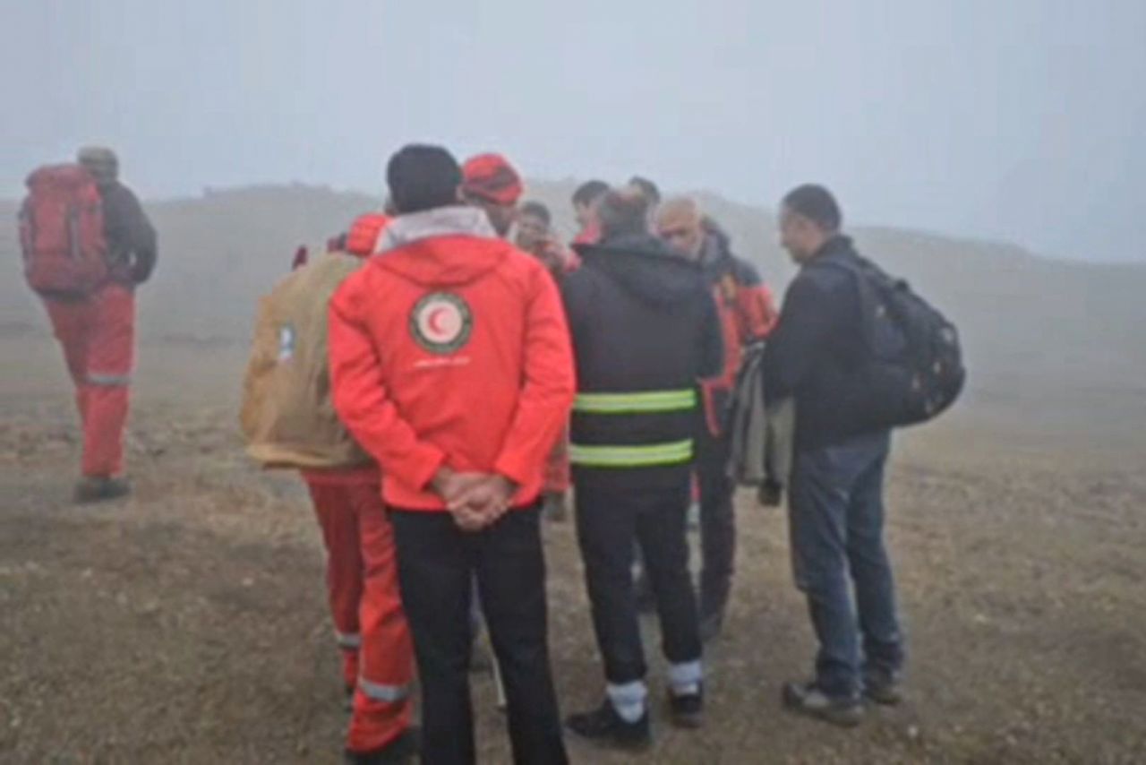 A screen grab from video released by Mehr News Agency via Telegram shows a rescue team arriving at the site of a helicopter crash in Iran on May 19.