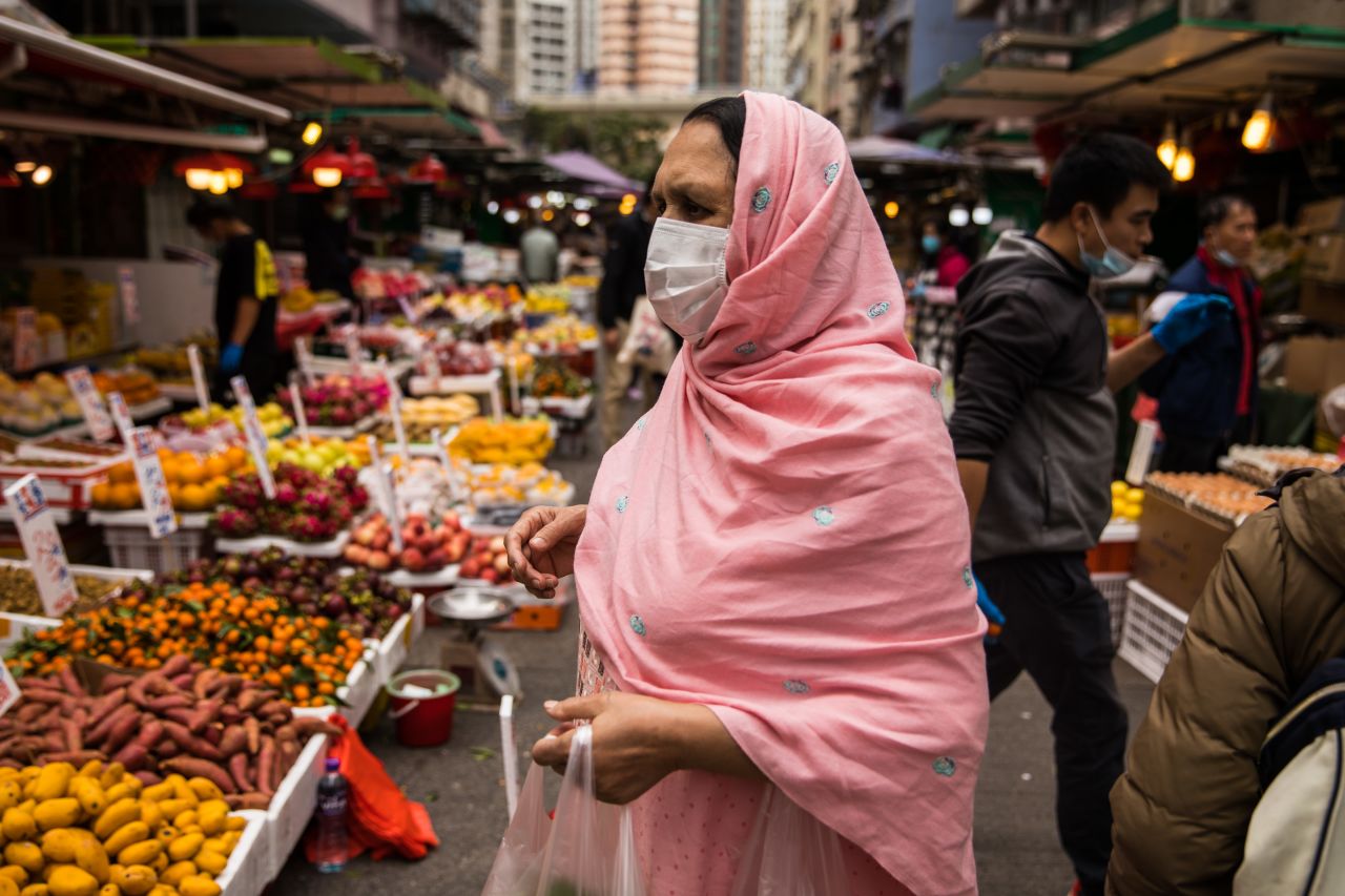 A woman wearing a protective face mask shops at a fresh food market in Hong Kong on Sunday.