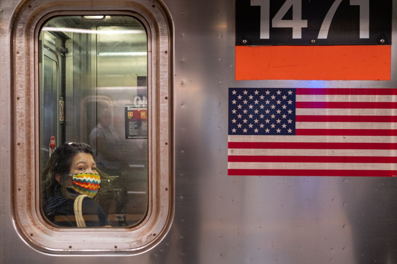 A woman wearing a mask rides the subway during rush hour on June 8, in New York City. 