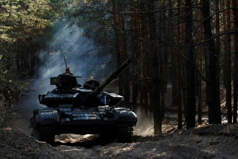 Ukrainian soldiers drive a captured Russian tank after re-fitting it for use in battle, in Kharkiv Oblast on October 15.