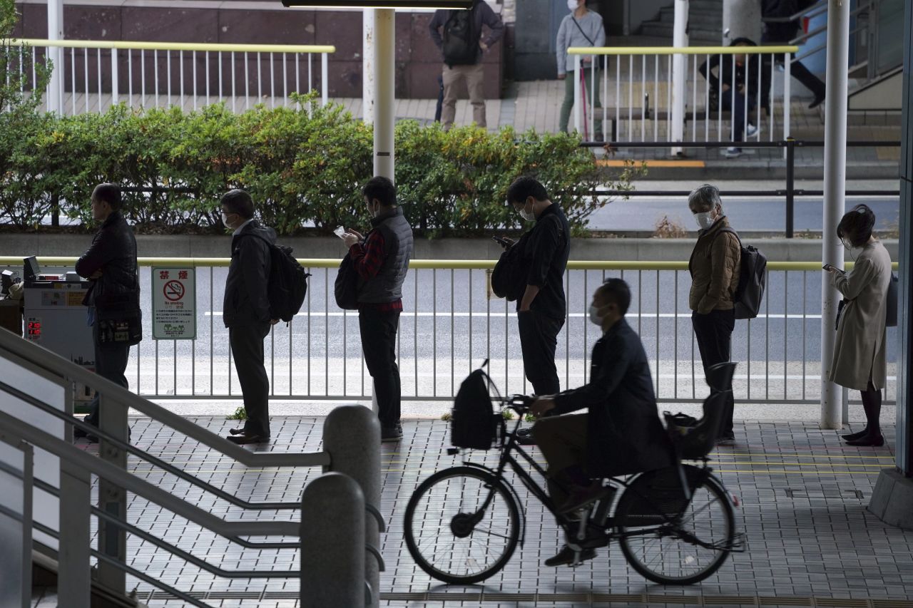 Commuters queue in line to wait for a bus during rush hour in Tokyo, Japan on November 20.