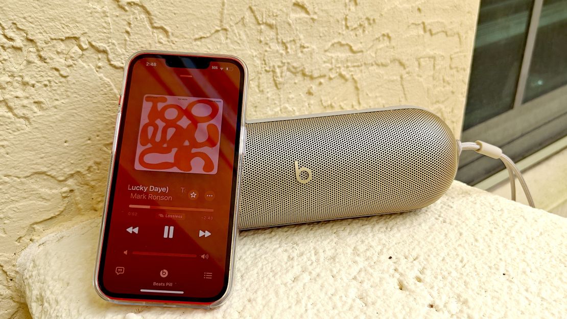 A iPhone playing Mark Ronson leans on a Beats Pill speaker.