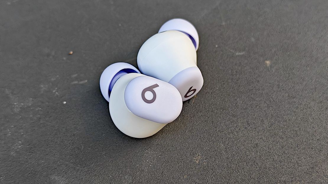 A closeup of the Beats Solo Buds on a dark surface.