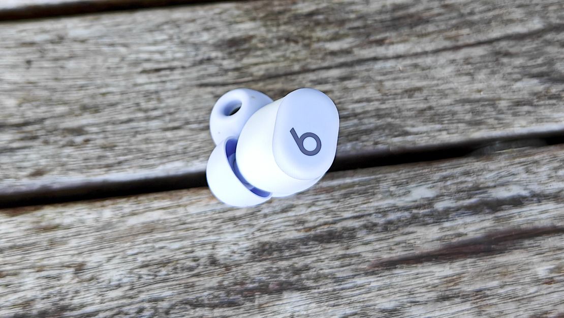 Beats Solo Buds earbud sits on a wooden surface